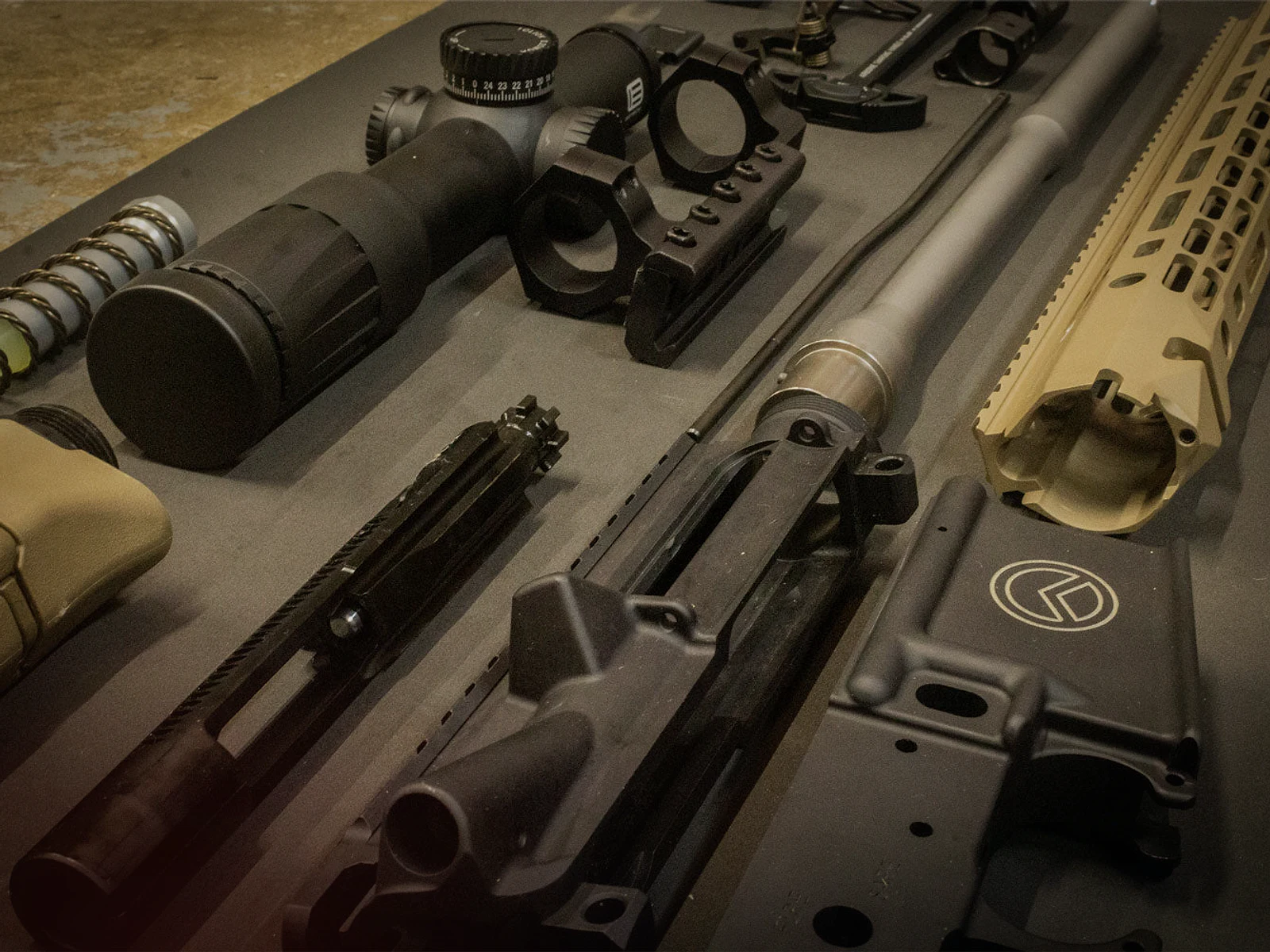 Rifle components, optics and gunsmithing tools arranged on a workbench