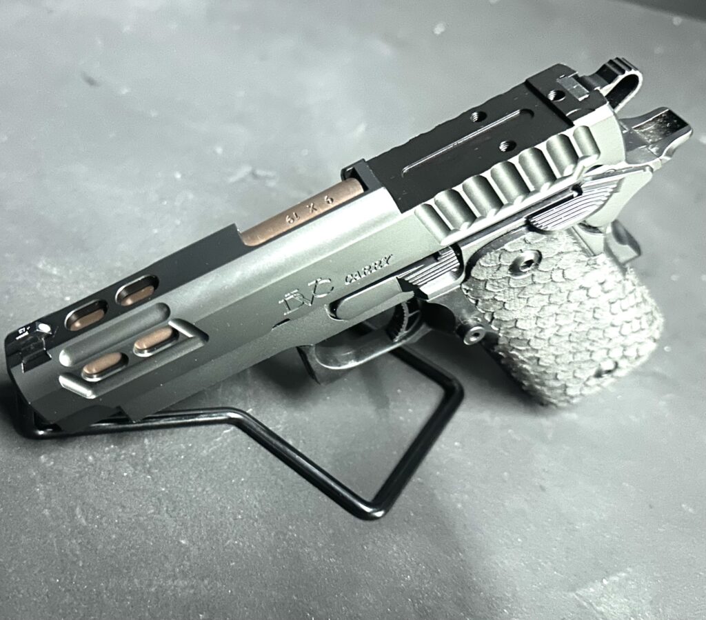 Pistol slide with optic mounting plate on the workshop bench