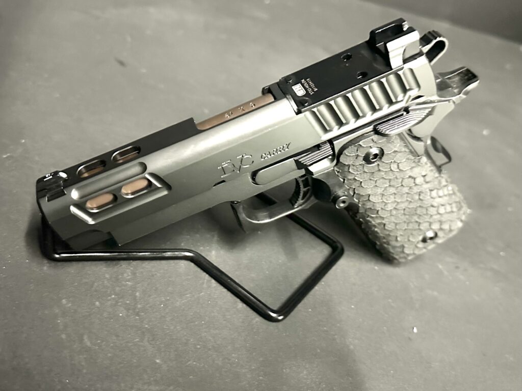 Pistol slide with Trijicon-marked optic mounting plate